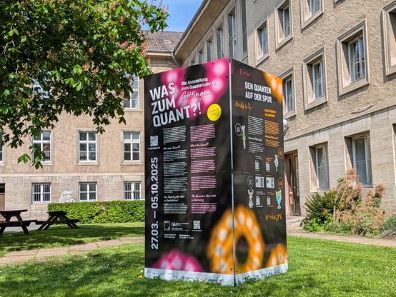 Informationssteele im Klein-Garten des Mathematischen Instituts mit Werbung für besagte Ausstellung