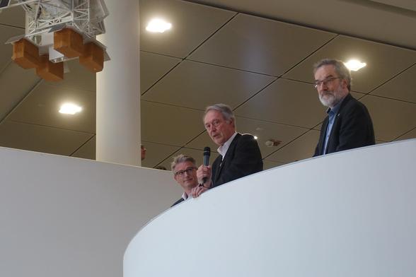Close-up of Axel Schölmerich, speaking into a microphone in his hand