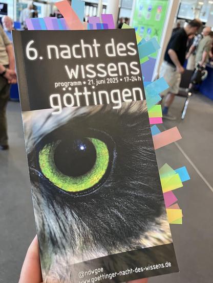 A night of science booklet in DIN LANG format with a large owl's eye on the title and the night of science text announcement. Sticking out at the top and to the right side of the thick booklet, there are lots and lots of colorful post-its.