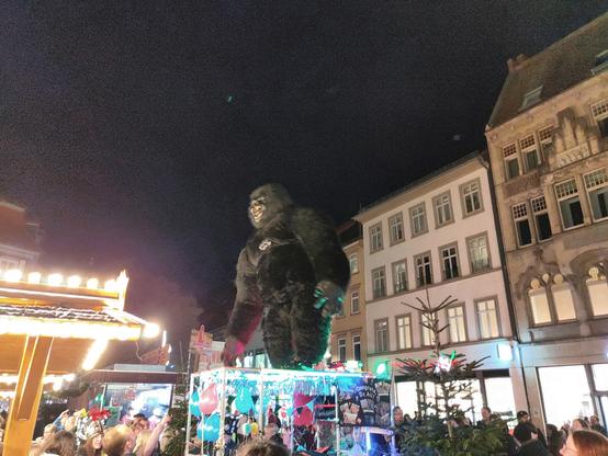 Towering high above crowds on a cart, a gorilla