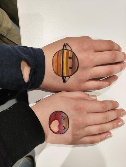 planets drawn on hands