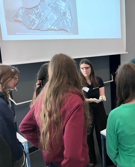 Scientist shows an etched iron meteorite to students